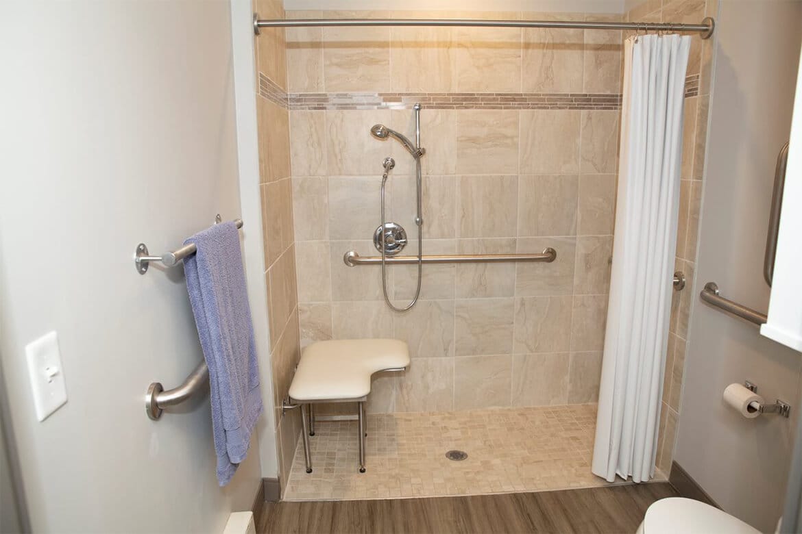 Resident rooms include a large walk-in shower with handheld sprayer.